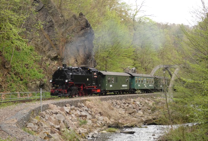 99&nbsp;1734 vor dem P&nbsp;5002 nun wieder ganz hoch fahrend mit Kipsdorf als Ziel, fotografiert an der bestens bekannten Weißeritz-Brücke hinter Rabenau, um 13:48h am 22.04.2025
