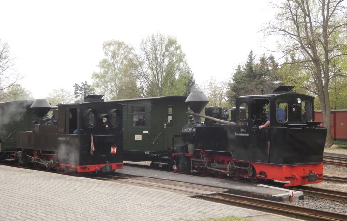 links 99&nbsp;3317&nbsp;Tv vor Zug nach Bad Muskau und rechts daneben 99&nbsp;3312&nbsp;Tv vor dem Zug Richtung Kromlau am Bahnsteig im Bahnhof Weißwasser-Teichstraße, um 9:34h am 18.04.2025