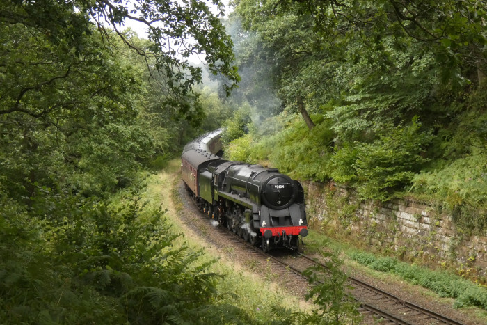 92134 (ex British Railways standard 9F) mit Zug Richtung Pickering, bei Beck Hole im Einschnitt vor der Straßenbrücke, um 15:01h am 27.08.2024