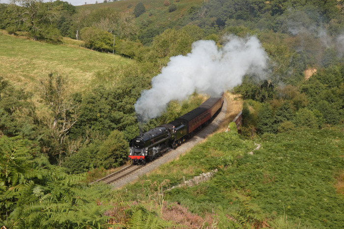 92134 mit dem ersten Zug des Tages in der Darnholm-Kurve, fotografiert vom Aussichtshang oben am footpath, um 10:54h am 29.08.2024